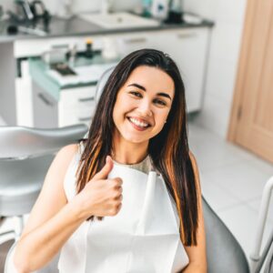 A women at the dentist giving a thumbs up
