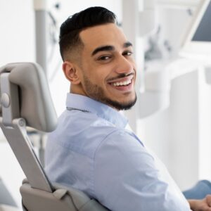 A man at the dentist looking back while smiling