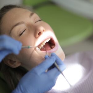 Close-up of dentist examining a patient's open mouth
