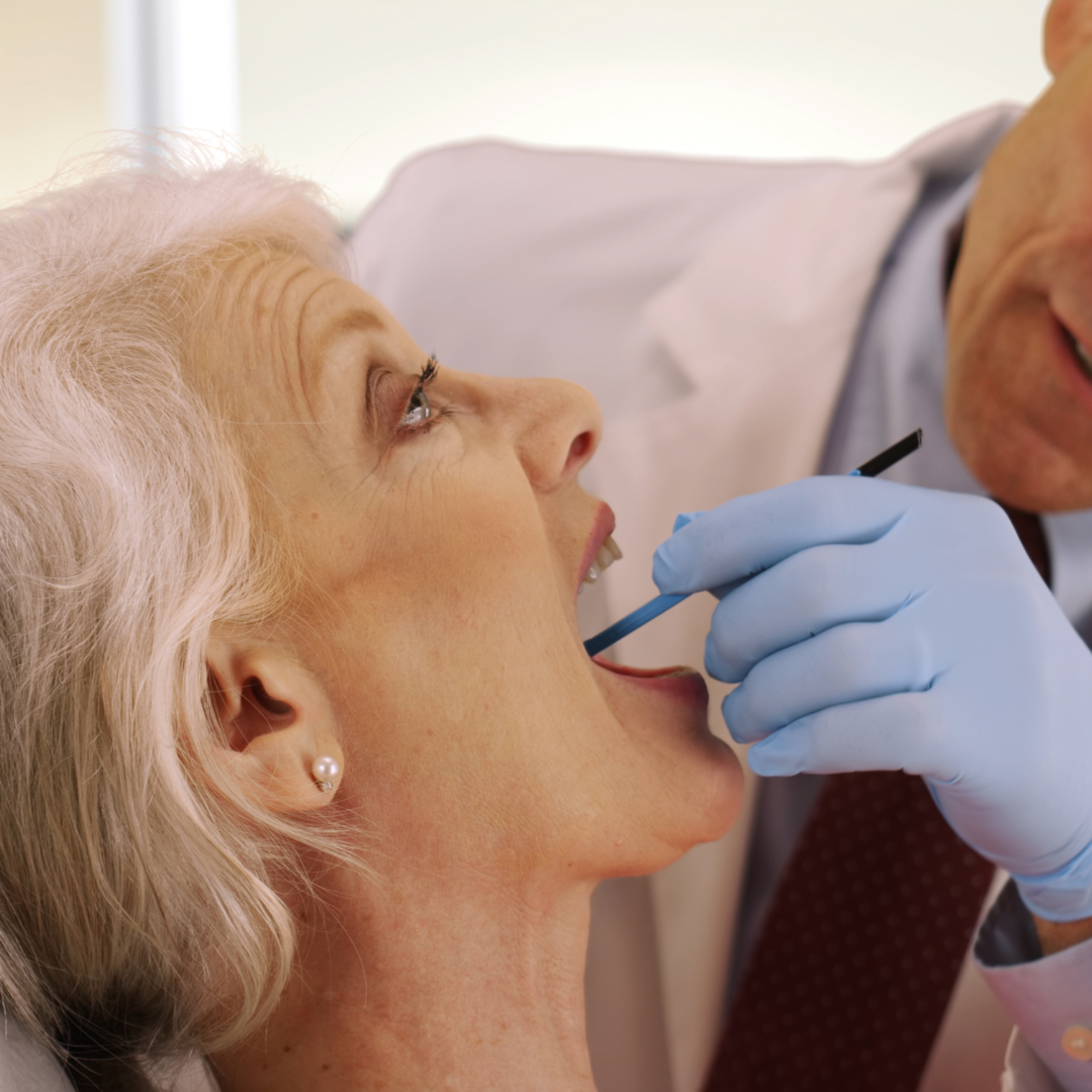 A dentist looking at a womens teeth